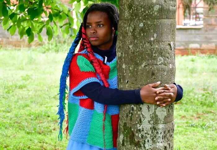 Truphena Muthoni hugging a tree during the 72-hour tree hugging feat