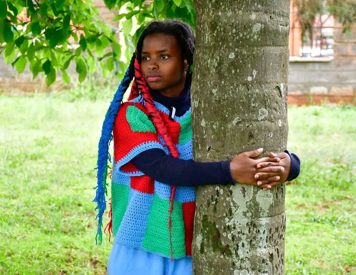 Truphena Muthoni hugging a tree during the 72-hour tree hugging feat