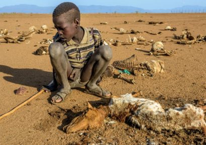 9-year-old Ejiem sits with the carcass of his favorite sheep, Merireng, in Turkana, Kenya. The East Africa drought has caused the death of many animals like Merireng. (©2017 World Vision/photo by Jon Warren)